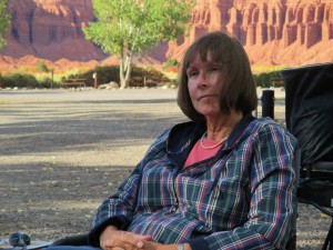 Relaxing by the campfire, the setting sun lighting the sandstone cliffs